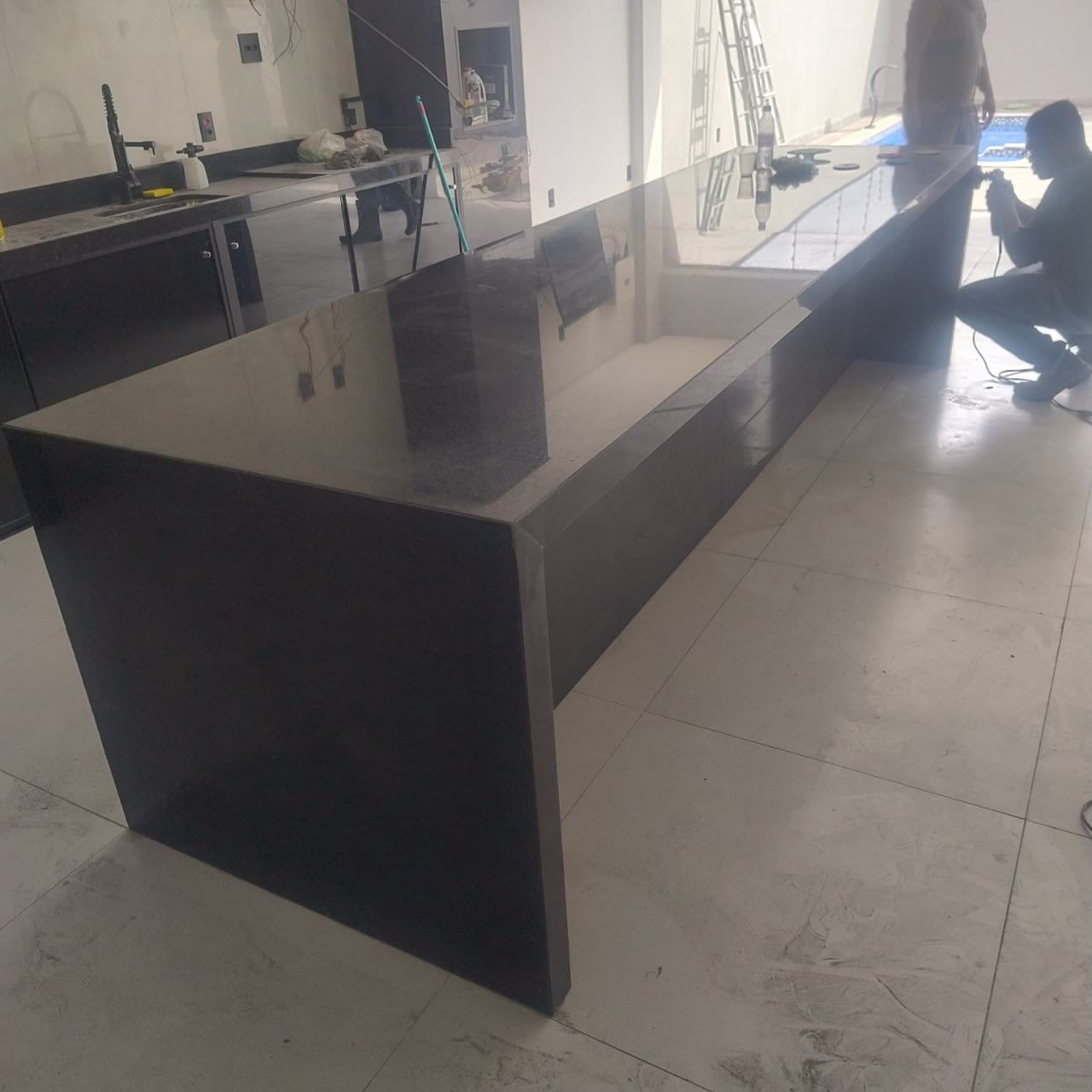 Profissional da equipe instalando uma ilha escura com cascata