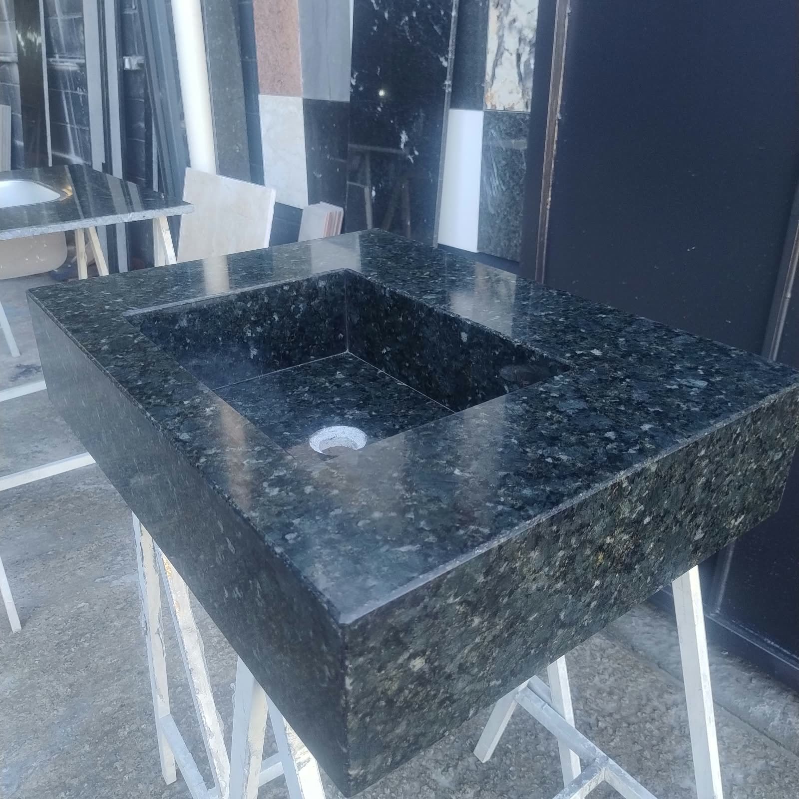 Lavatório monobloco de granito verde com cuba esculpida na própria pedra