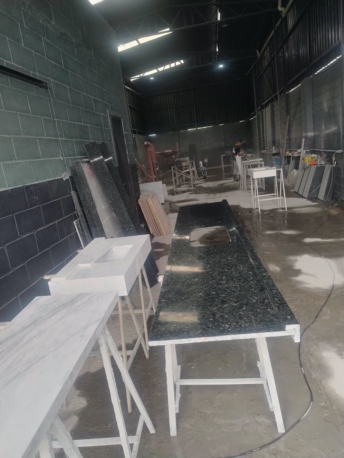 Galpão da oficina com bancadas e lavatórios prontos sobre cavaletes
